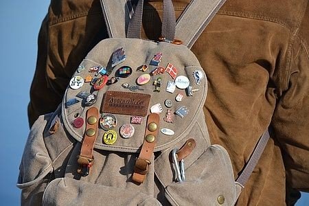 Billede af rygsæk med mange mærker og badges. 